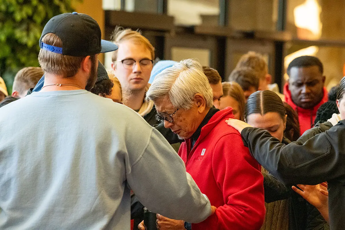 A group of people join together in prayer