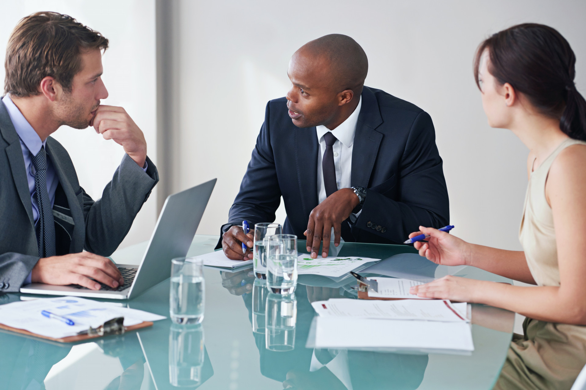 2 men and 1 woman working together around a table